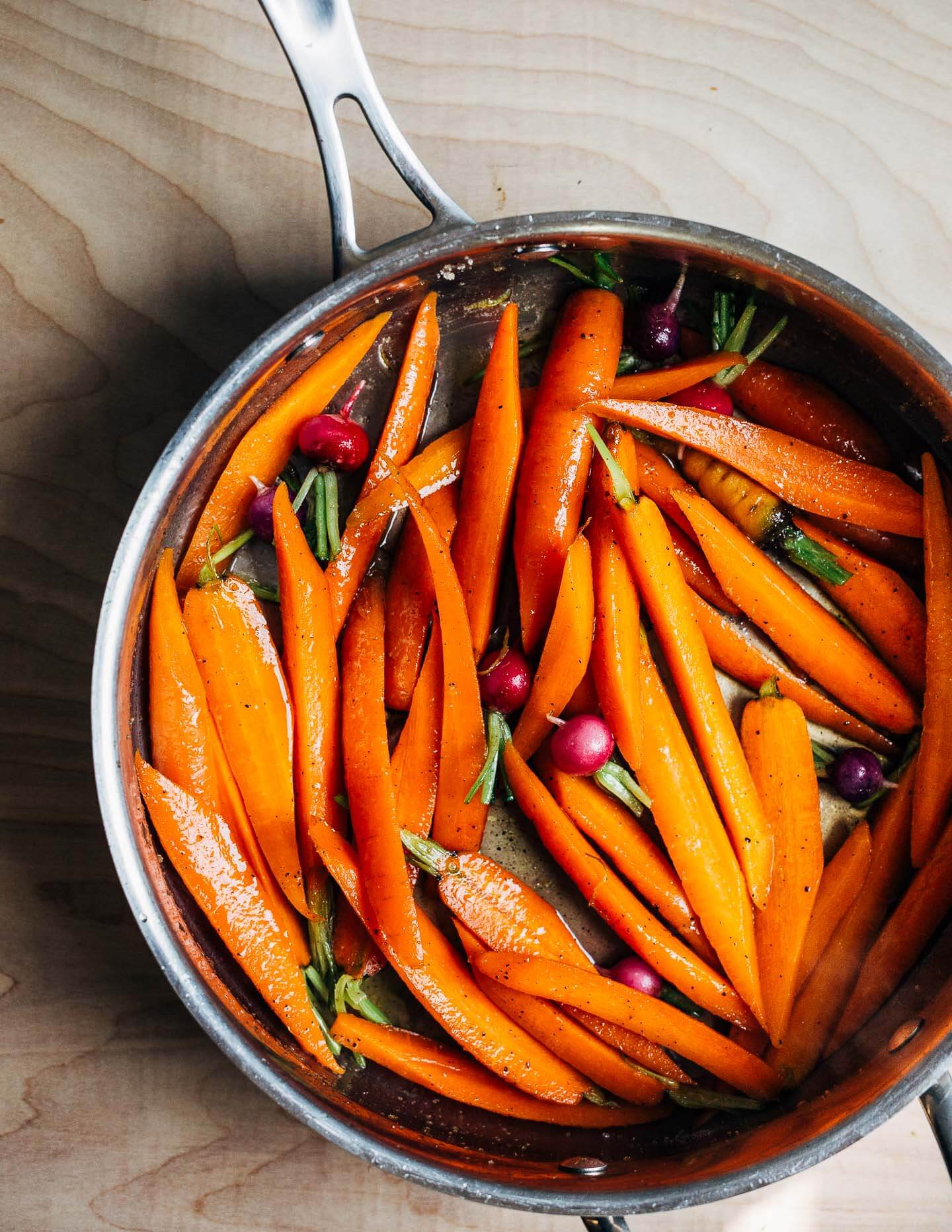 These springy glazed carrots are delightfully buttery and light with a vegetable broth-based glaze and are served alongside a bright carrot top chimichurri.