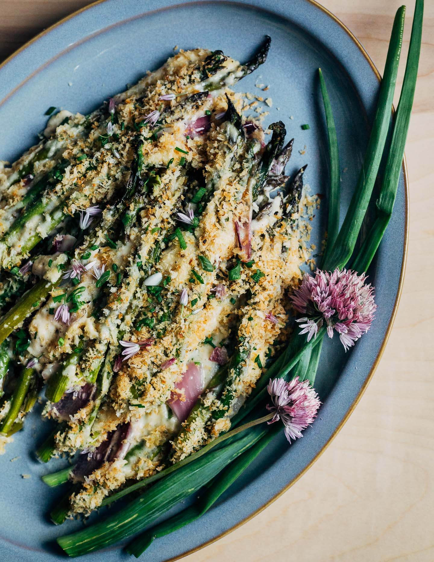 A blue patter with asparagus gratin and chive blossom and spring onion garnishes