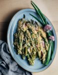 A blue patter with asparagus gratin and chive blossom and spring onion garnishes