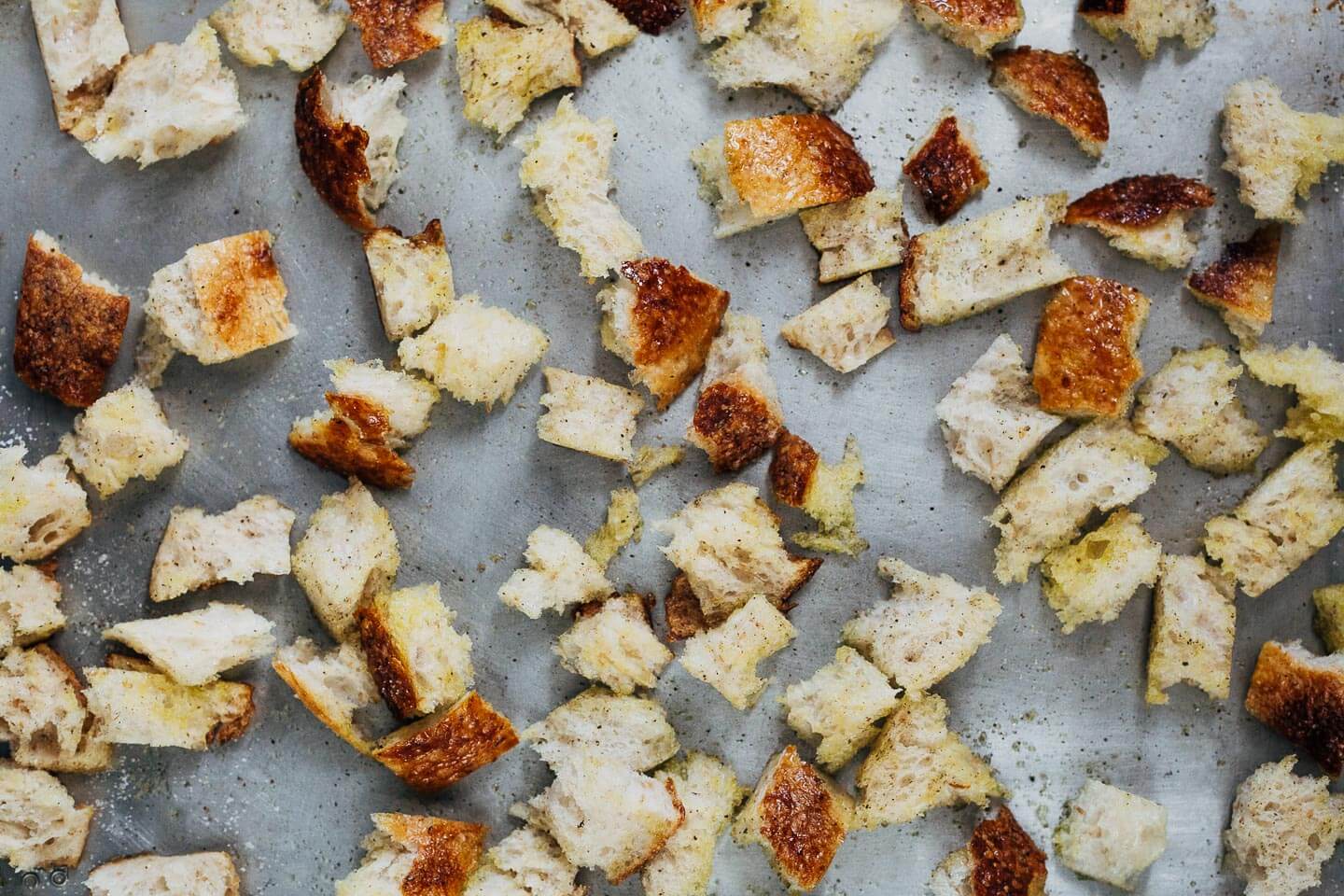 A sheet pan with torn bits of bread