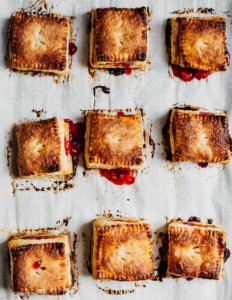 A baking sheet with nine square strawberry basil hand pies.