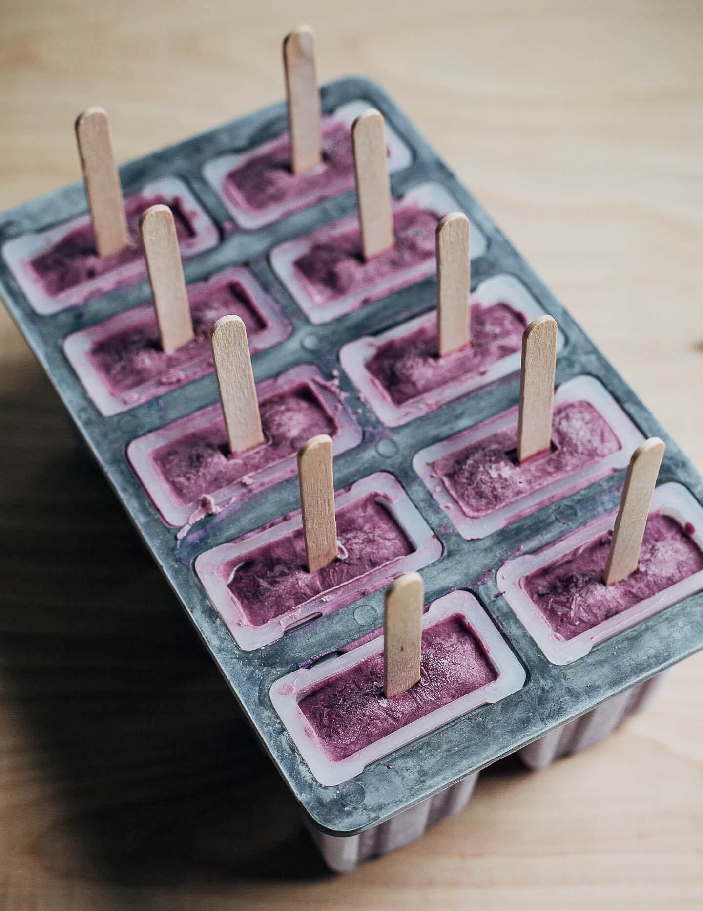 A popsicle mold with frozen blueberry popsicles. 