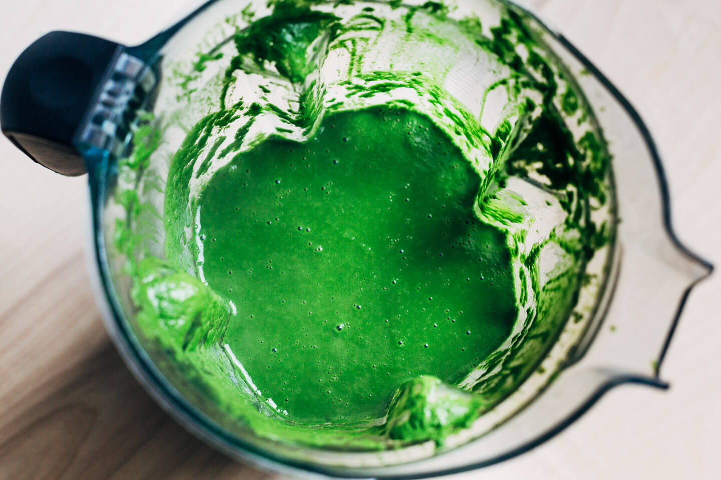 A blender with green kale sauce.