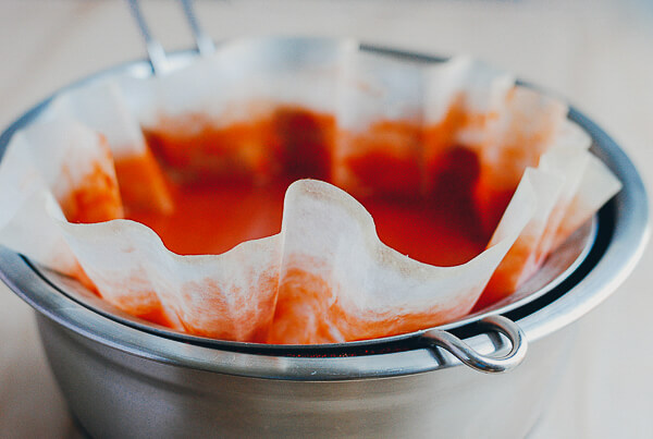 A strainer filled with tomato juices. 