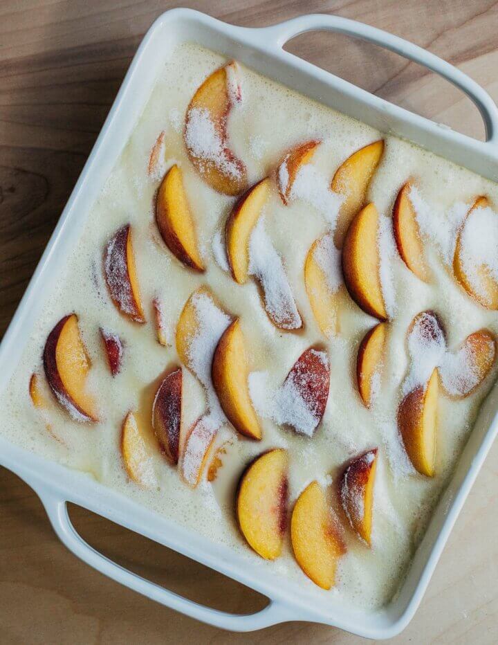 A french custard cake with peaches, ready to be baked. 