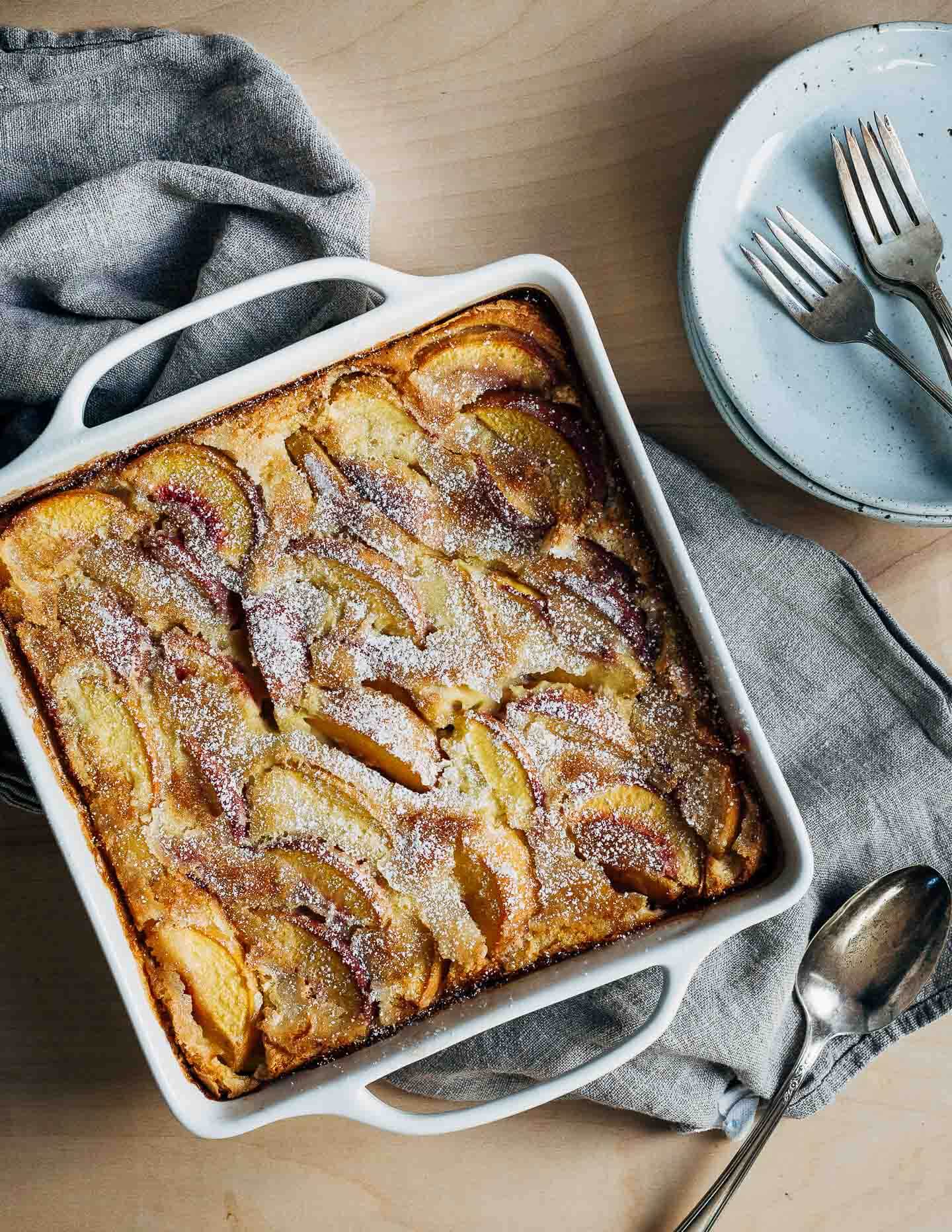 A french custard cake, ready to serve, with plates and forks alongside. 