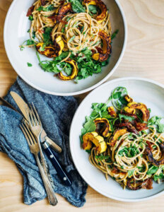 Two bowls with spaghetti and roasted delicata squash.