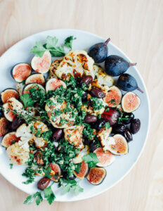A platter with roasted cauliflower, figs, and greens.