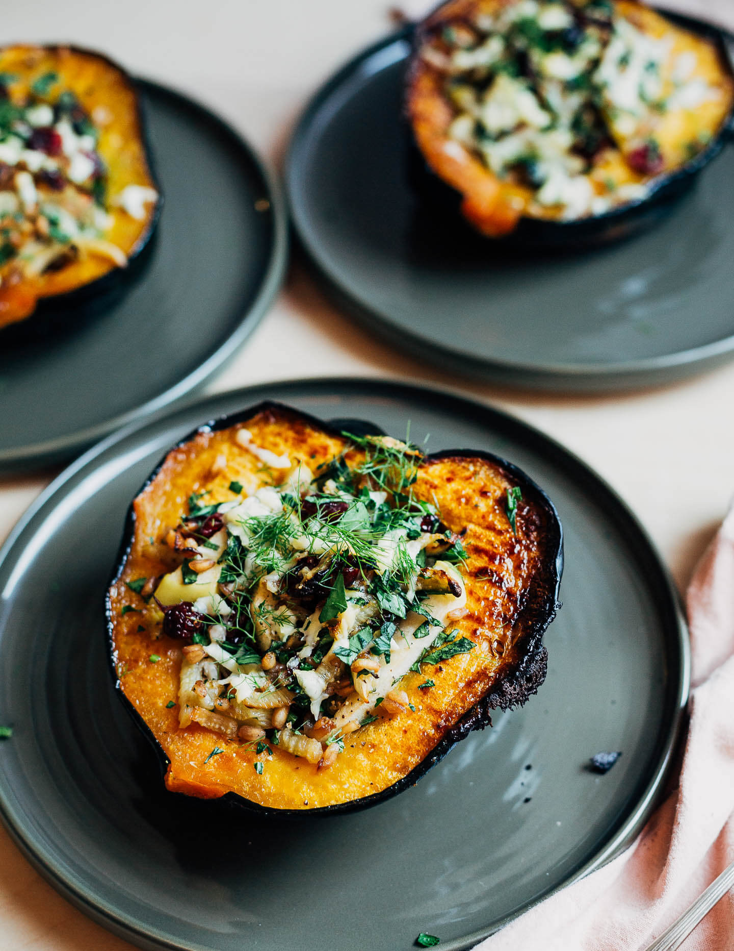 Stuffed acorn squash halves served on a plate. 