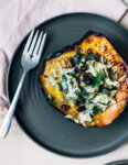 A stuffed acorn squash half served on a plate.