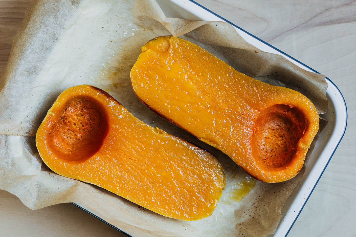 Baked butternut squash halves in a baking dish. 