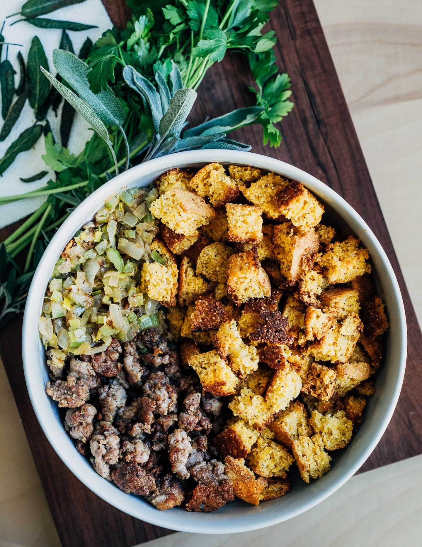 A mixing bowl and cutting board with stuffing ingredients. 