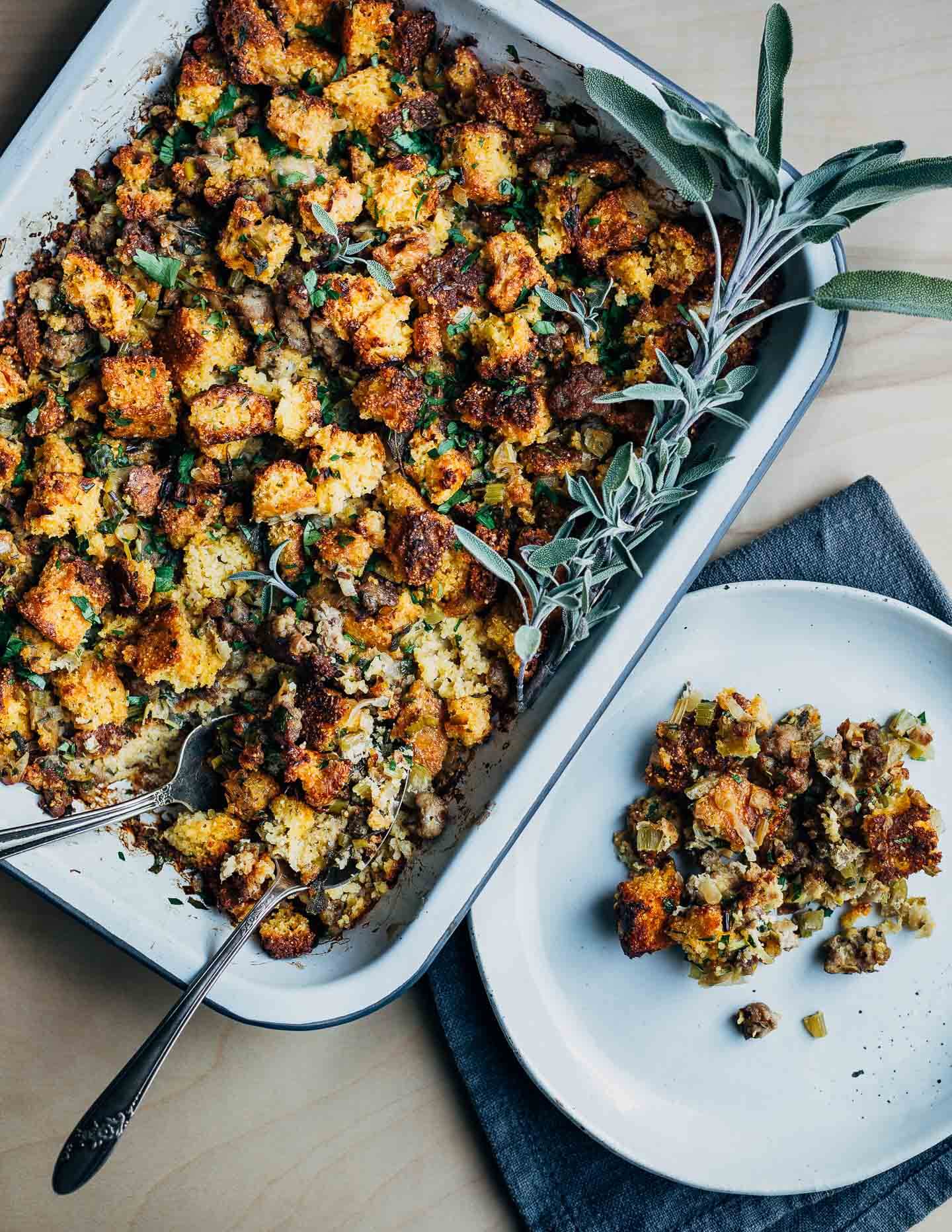 A baking dish of cooked stuffing and a serving plate with stuffing. 