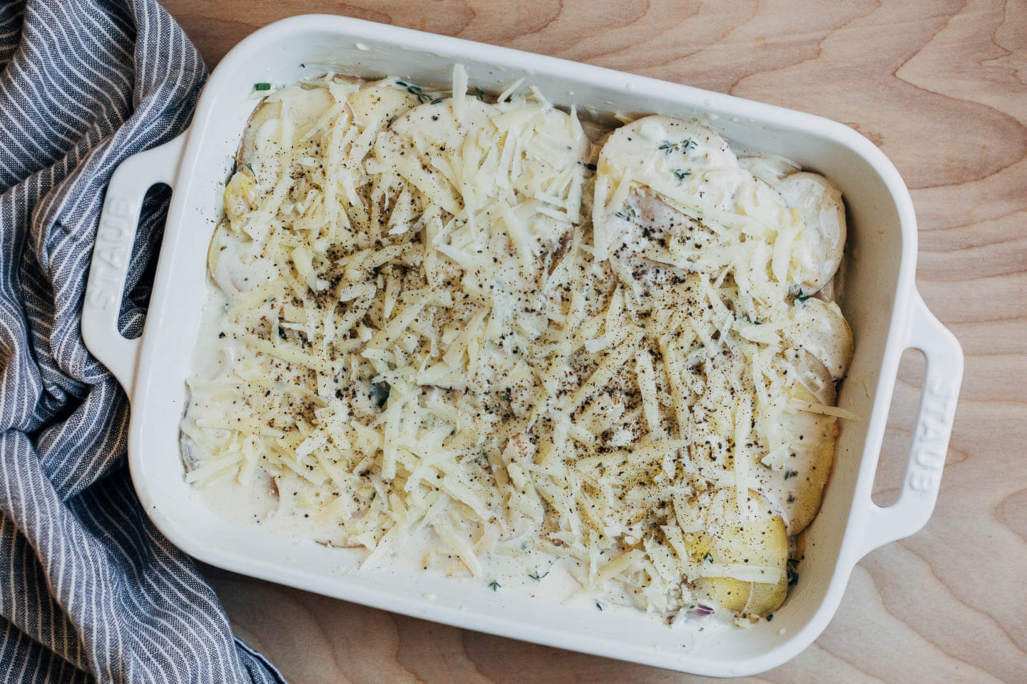 Unbaked potatoes in a baking dish. 