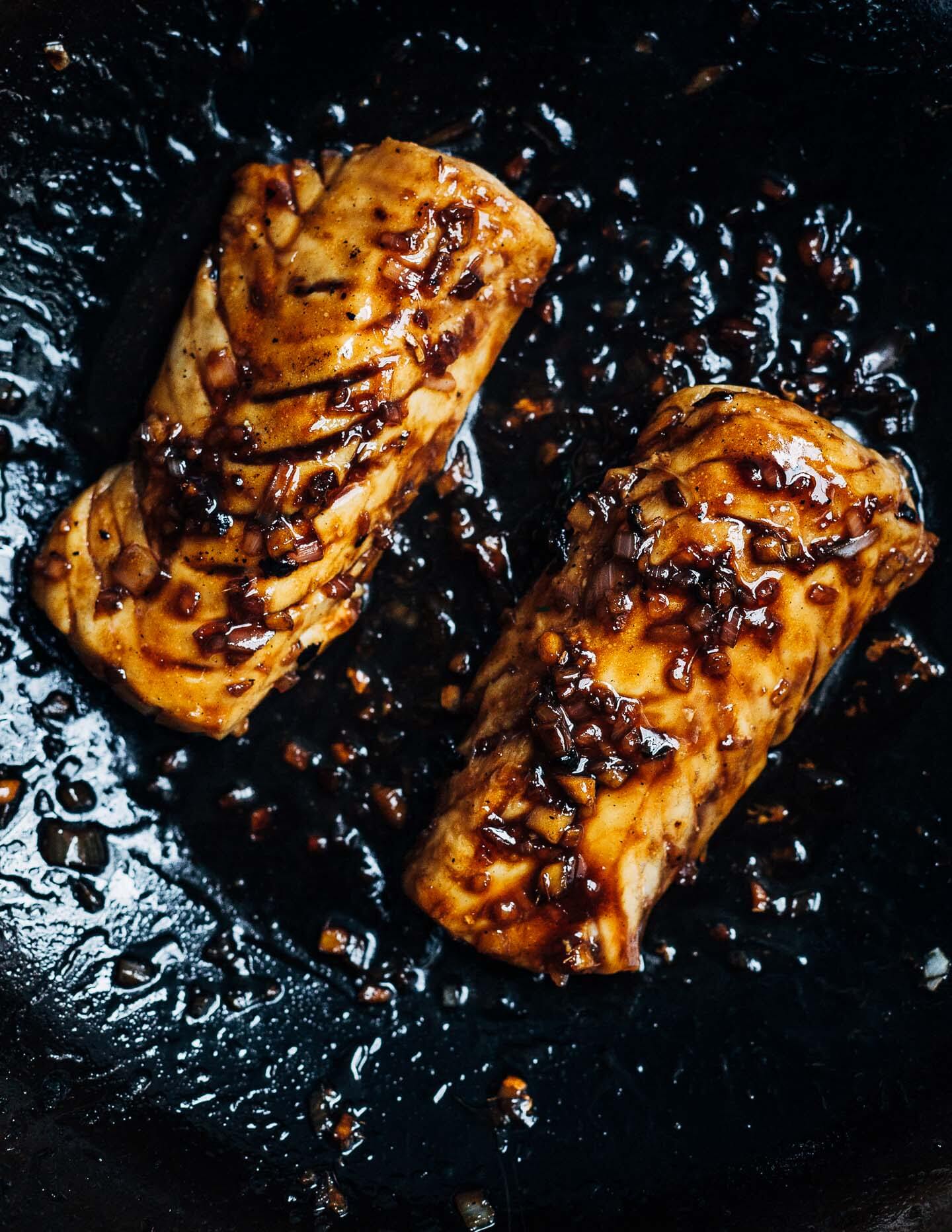 Two glazed cod filets in a wok. 