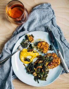 A plate with golden fritters, greens, and aioli