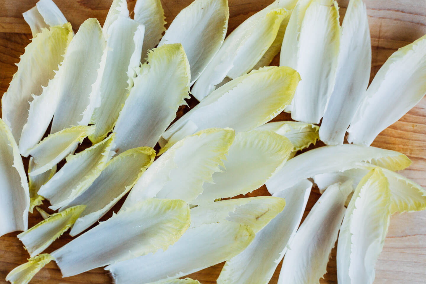Endive leaves spread out on a cutting board. 