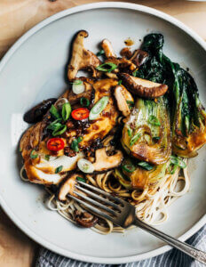 A low bowl with glazed cod, bok choy, and mushrooms.