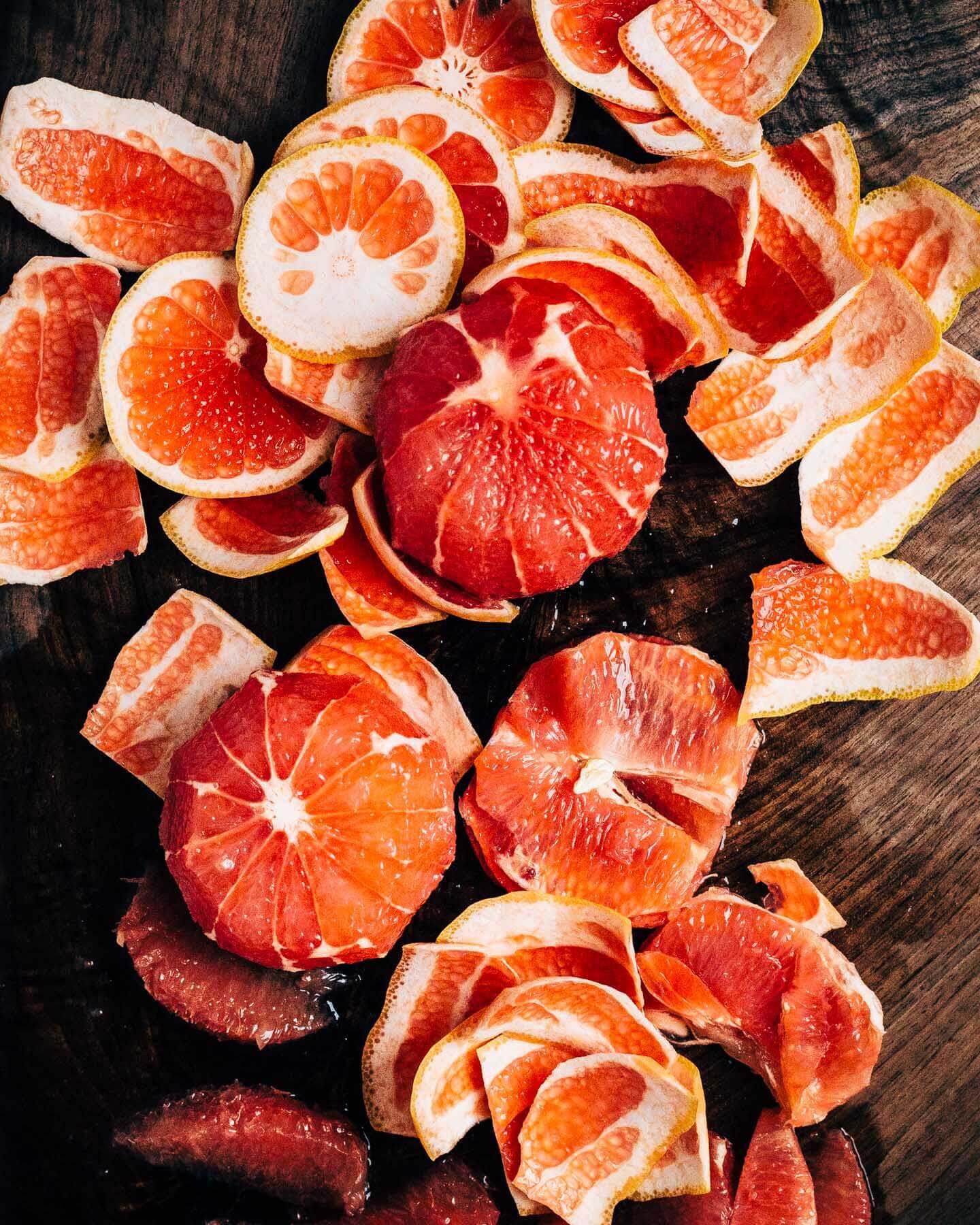 A cutting board with peeled grapefruits.