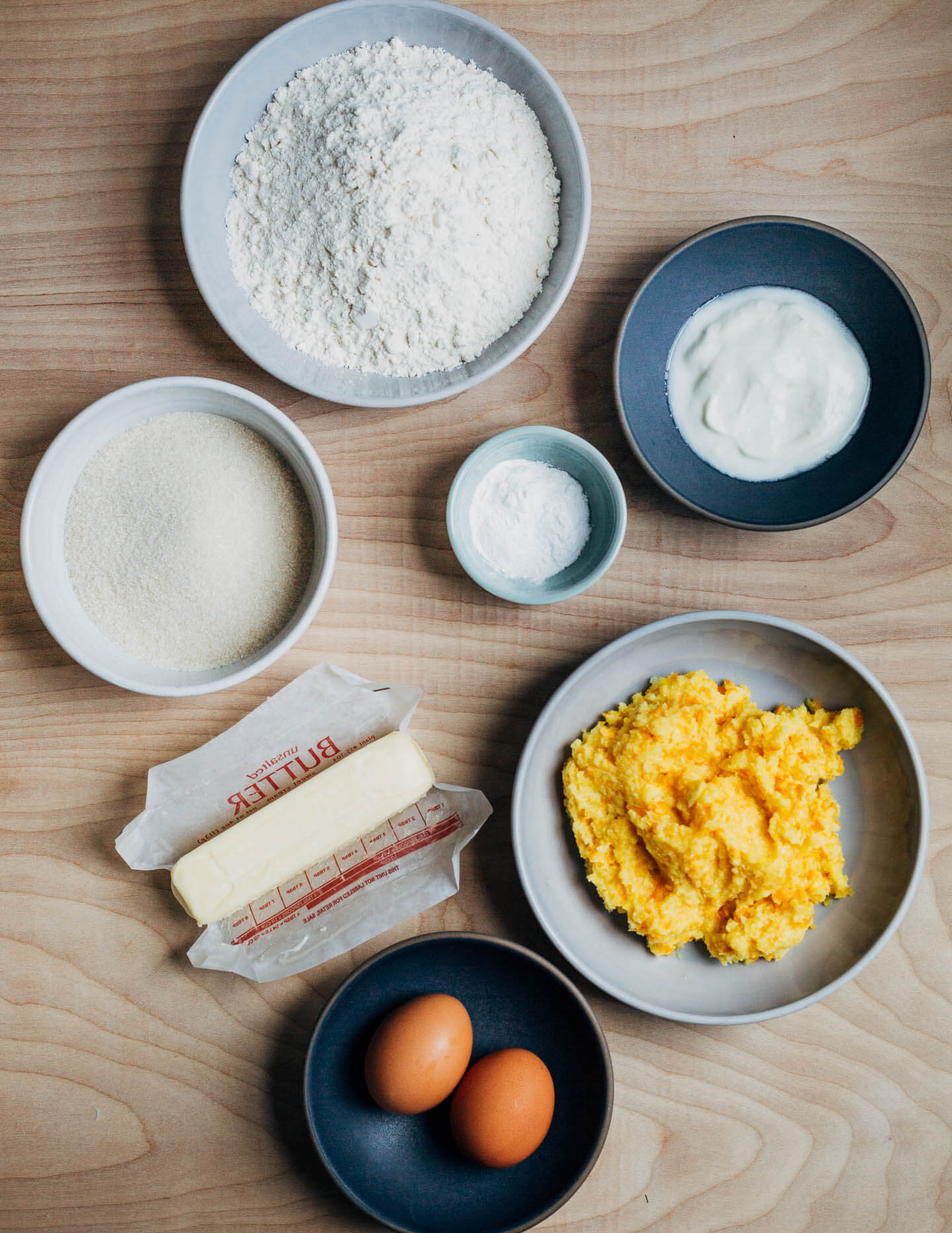 Ingredients for making a cake laid out in small bowls. 