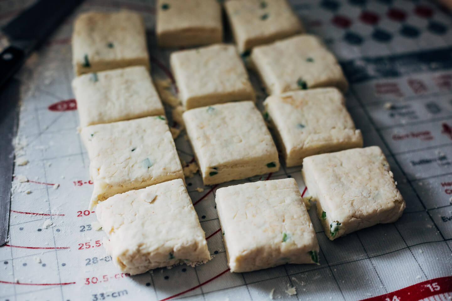 Biscuit dough cut into square biscuits. 