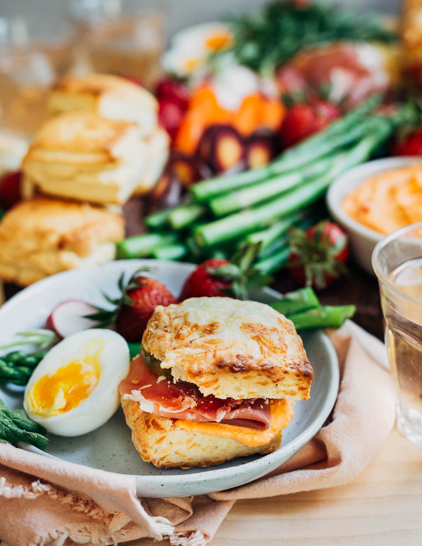 A biscuit sandwich with an egg and asparagus alongside.