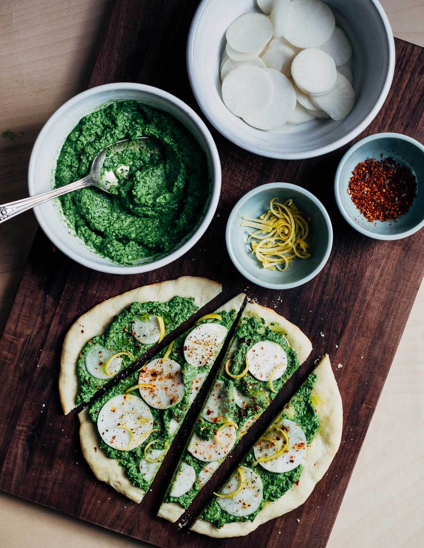 Ingredients laid out on a cutting board with a prepped flatbread. 