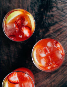 An overhead view of three glasses of strawberry lemonade,