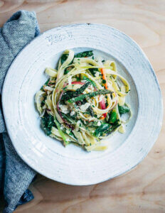 A plate of fettuccine swirled with spring vegetables and herbs.