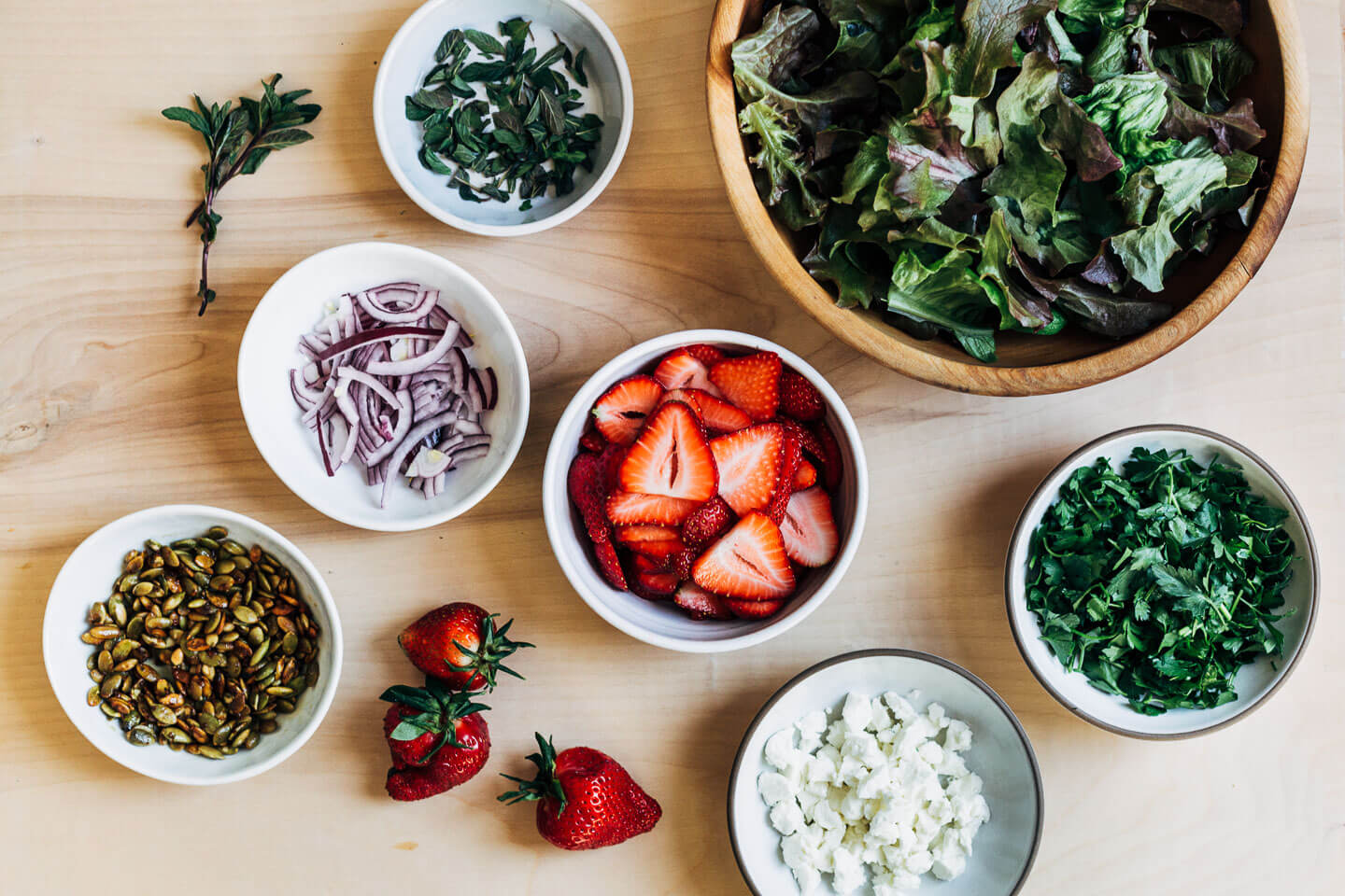 Salad ingredients laid out in little bowls. 