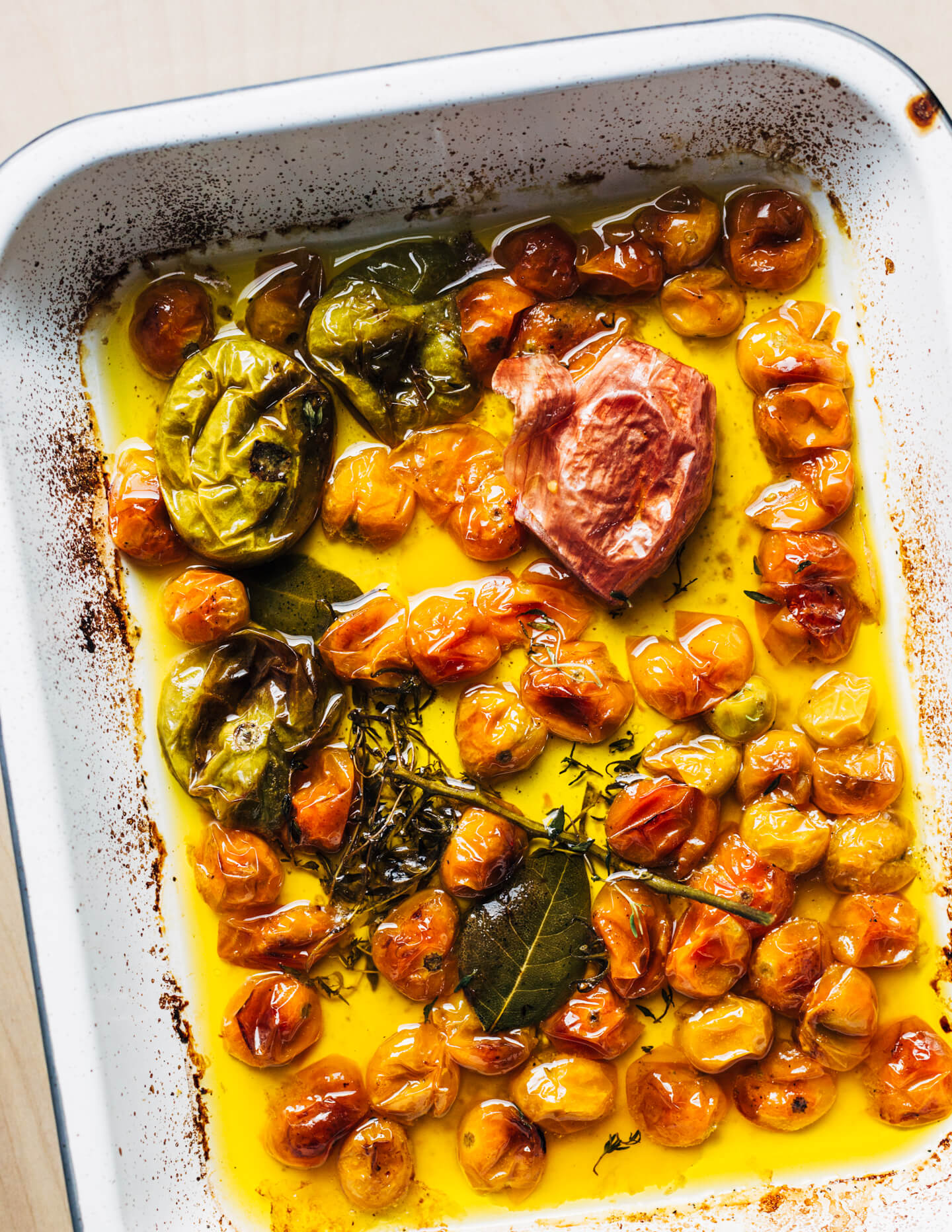 A baking dish with cooked yellow cherry tomato confit.