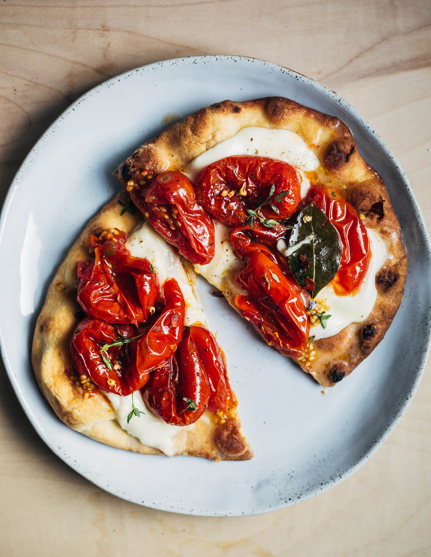 Tomato confit spread over melted mozzarella on a toasted flatbread. 