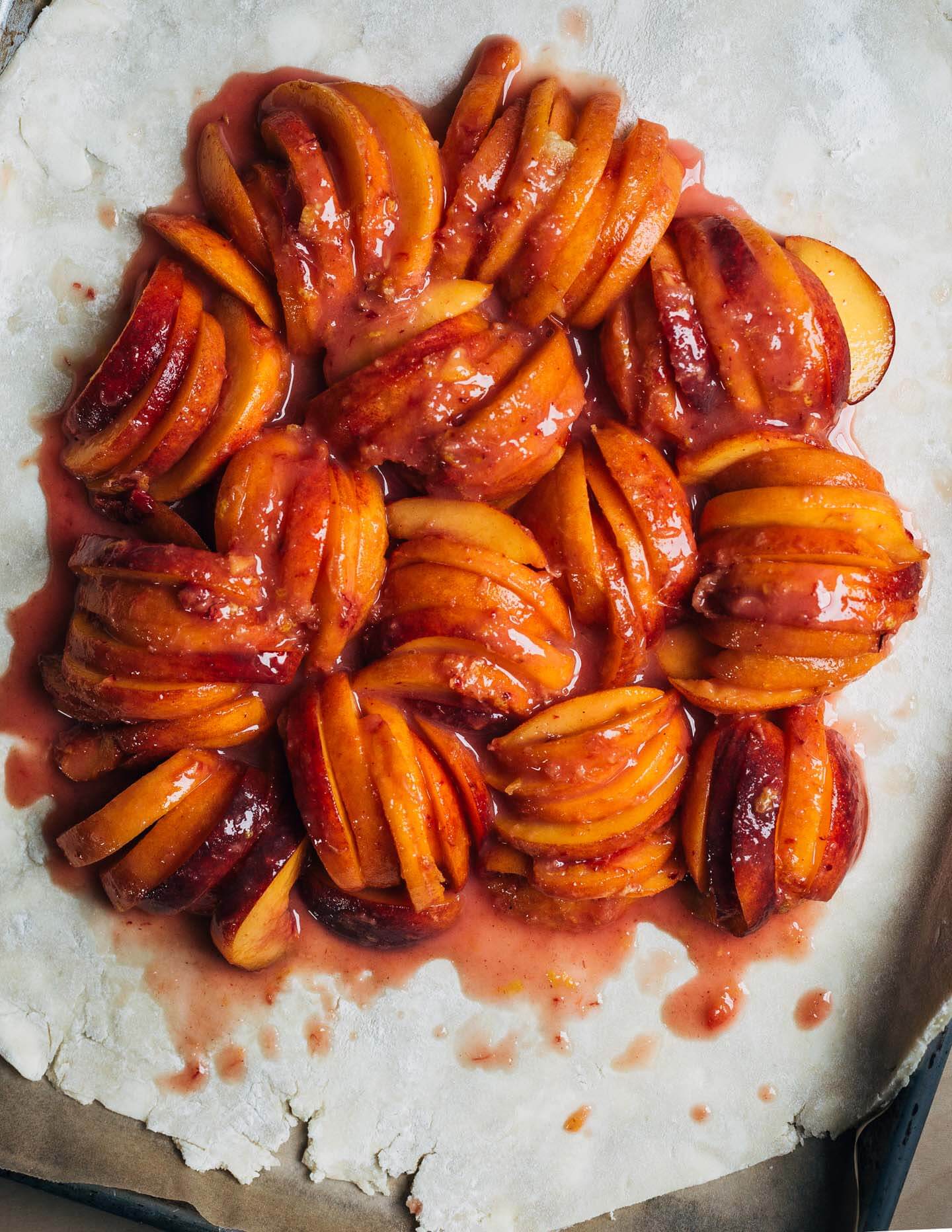 Peach filling on a rolled-out round of pastry dough. 