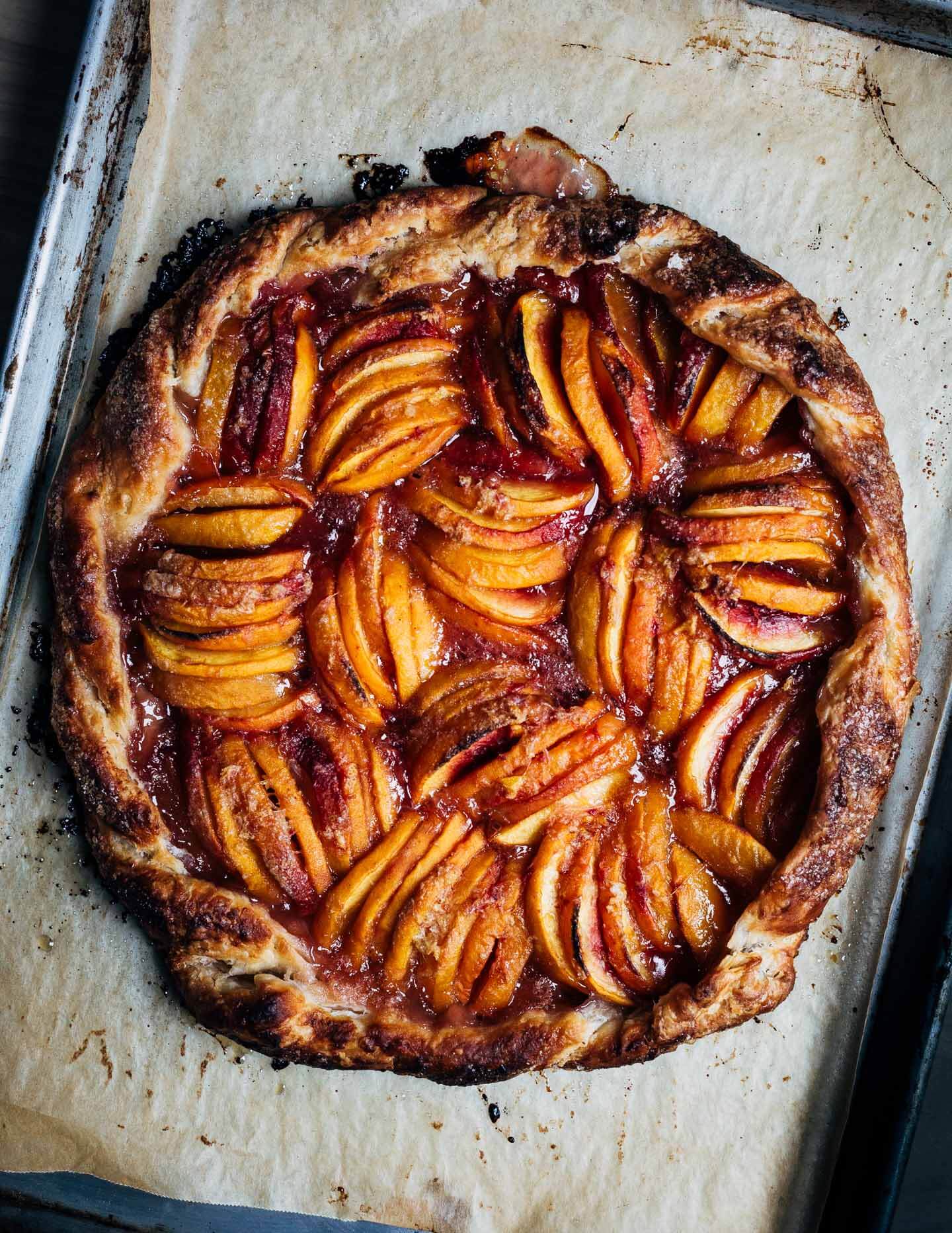 A ginger peach galette on a baking sheet just out of the oven,
