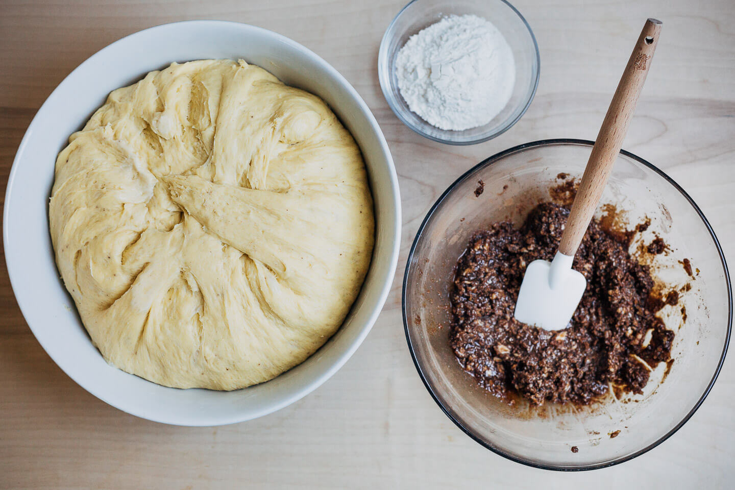 Dough, filling, and flour for rolling and assembling cinnamon rolls. 