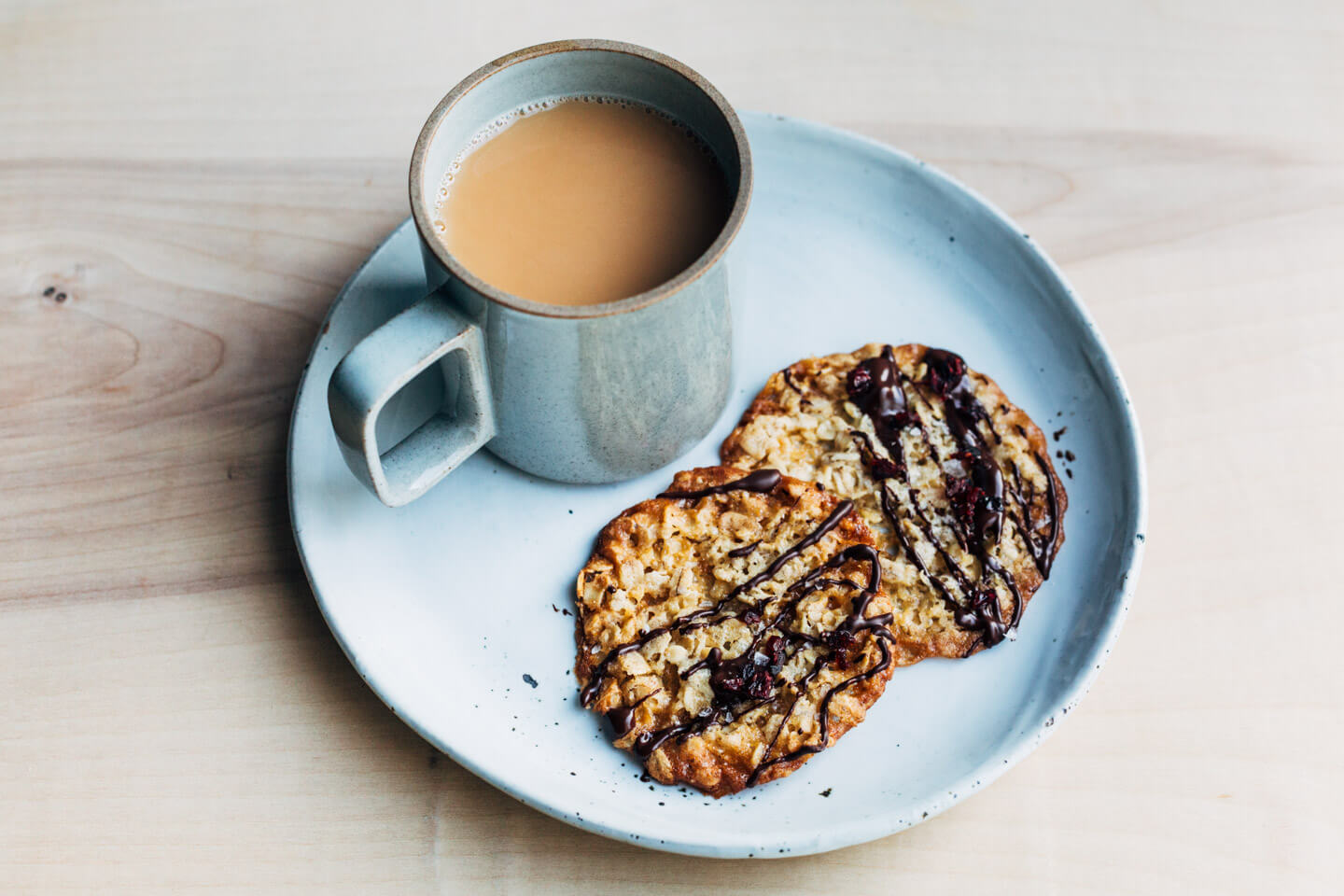 A mug of tea and two cookies on a plate