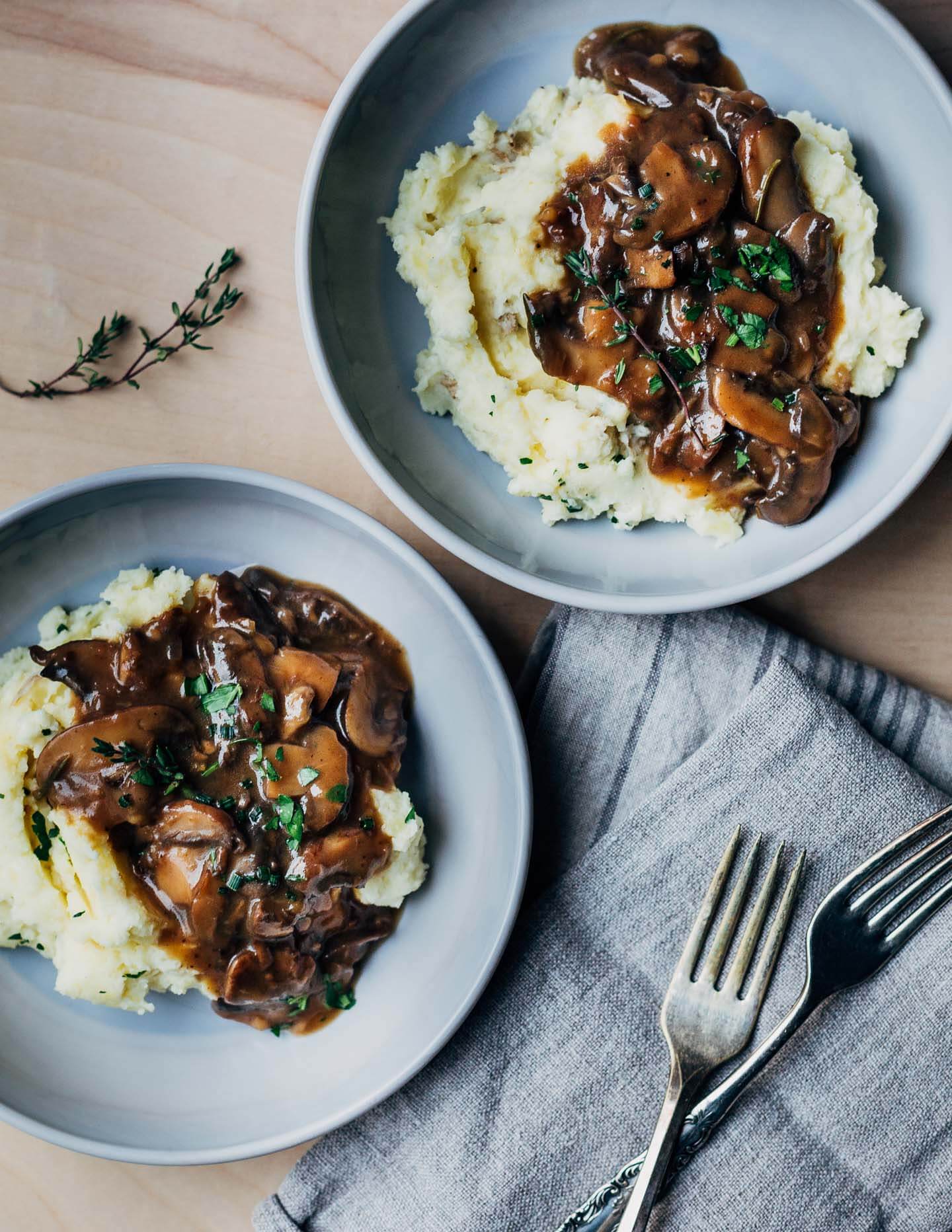 Two bowls of mashed potatoes with gravy.