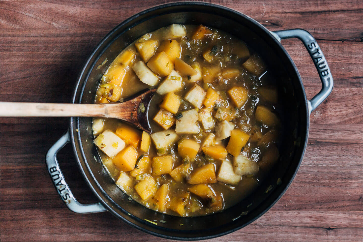 A soup pot with cubed celery root and rutabaga