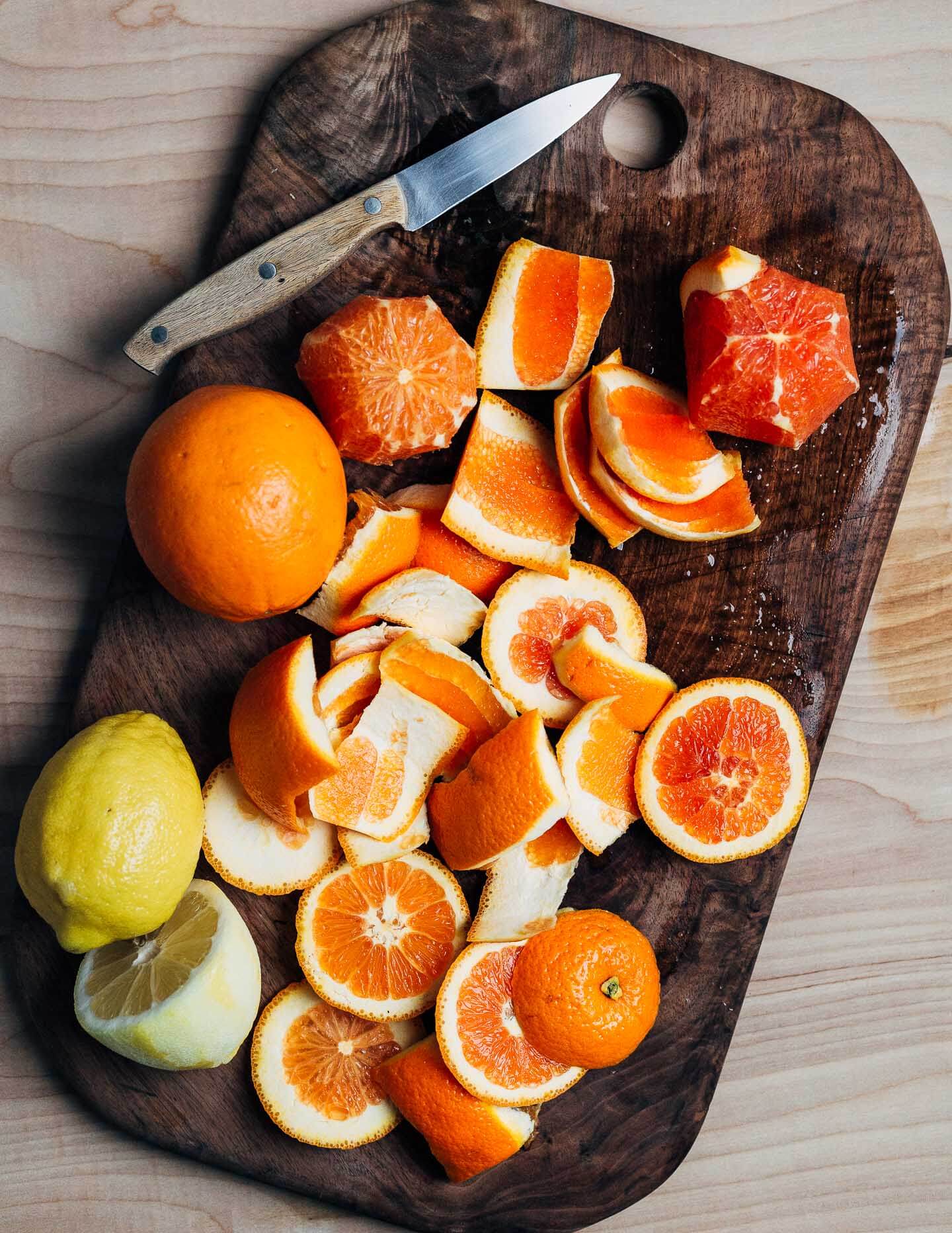 Sliced oranges and peels on a cutting board. 