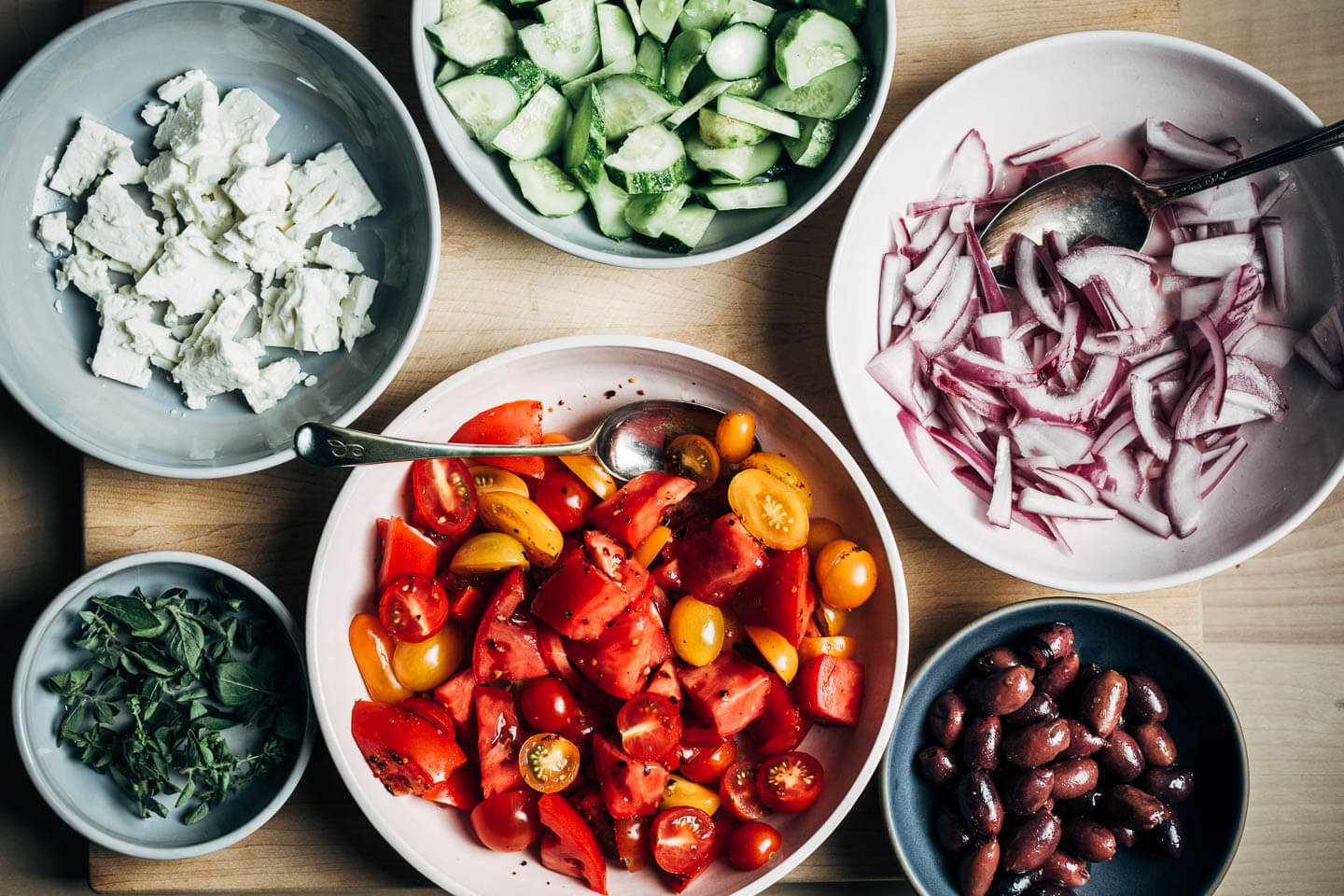 Little bowls of vegetables, olives, and feta. 